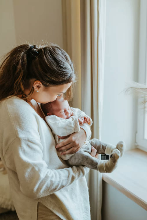 Mère tenant son nouveau-né contre elle